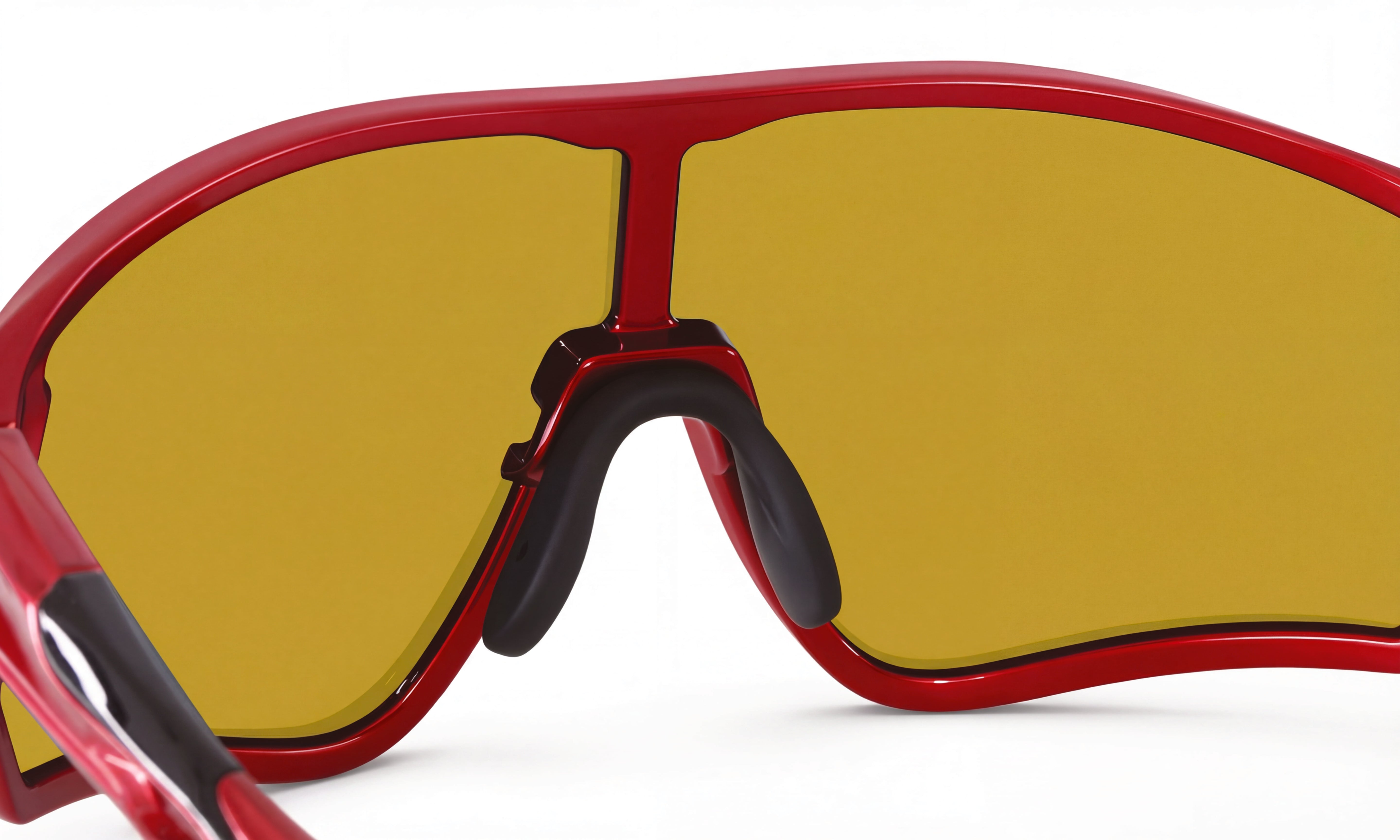 Close-up of red cycling sunglasses with yellow wraparound lens and black nose pads