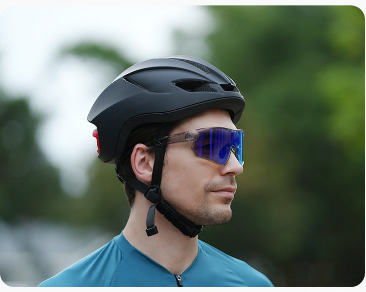 Man wearing cycling sunglasses with blue mirrored lenses and a black bike helmet outdoors