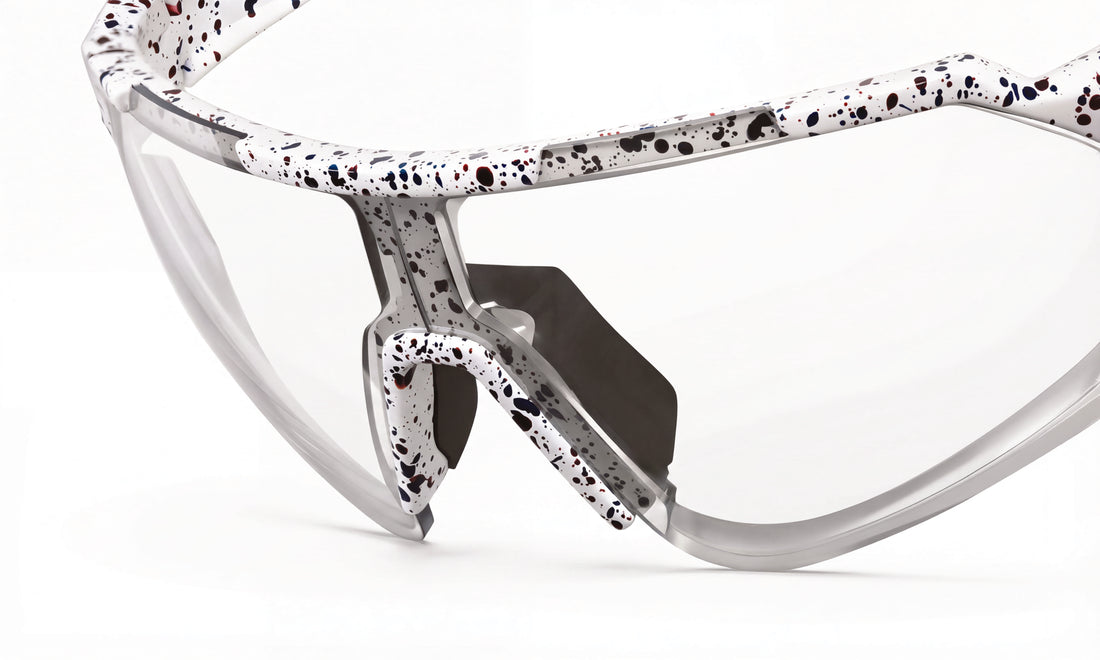 Clear lens cycling sunglasses with white and black speckled frame, close-up view